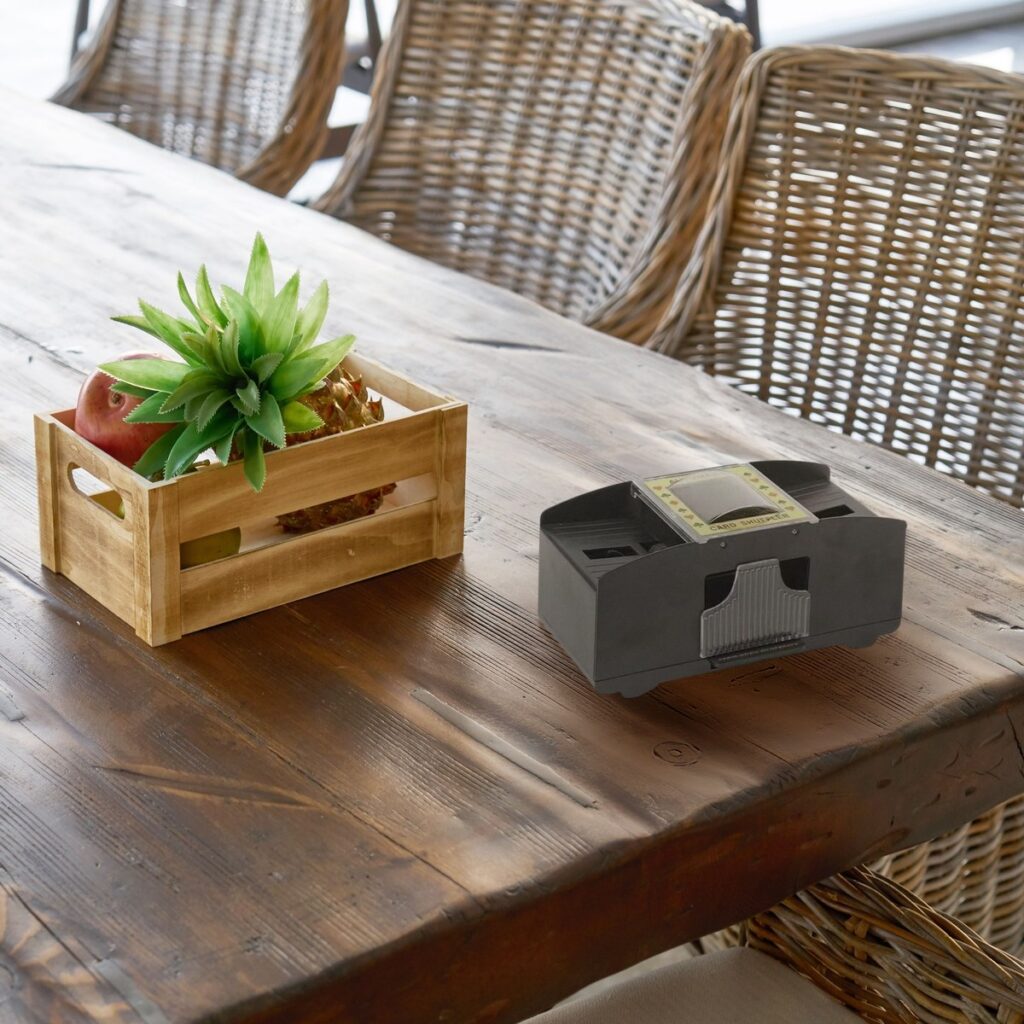 Mélangeur de cartes électrique à piles, 2 jeux, sur une grande table en bois dans une véranda (mise en scène)