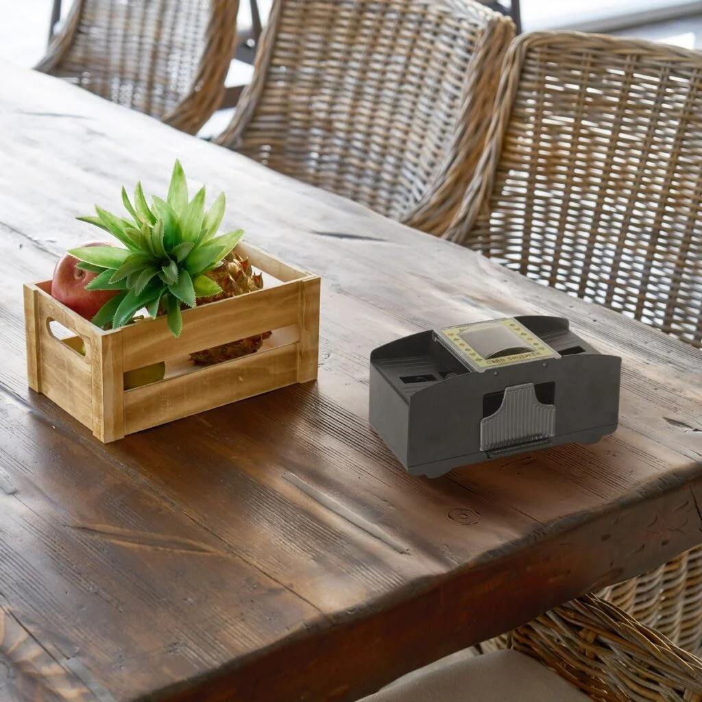 Mélangeur de cartes électrique à piles, 2 jeux, sur une grande table en bois dans une véranda (mise en scène)