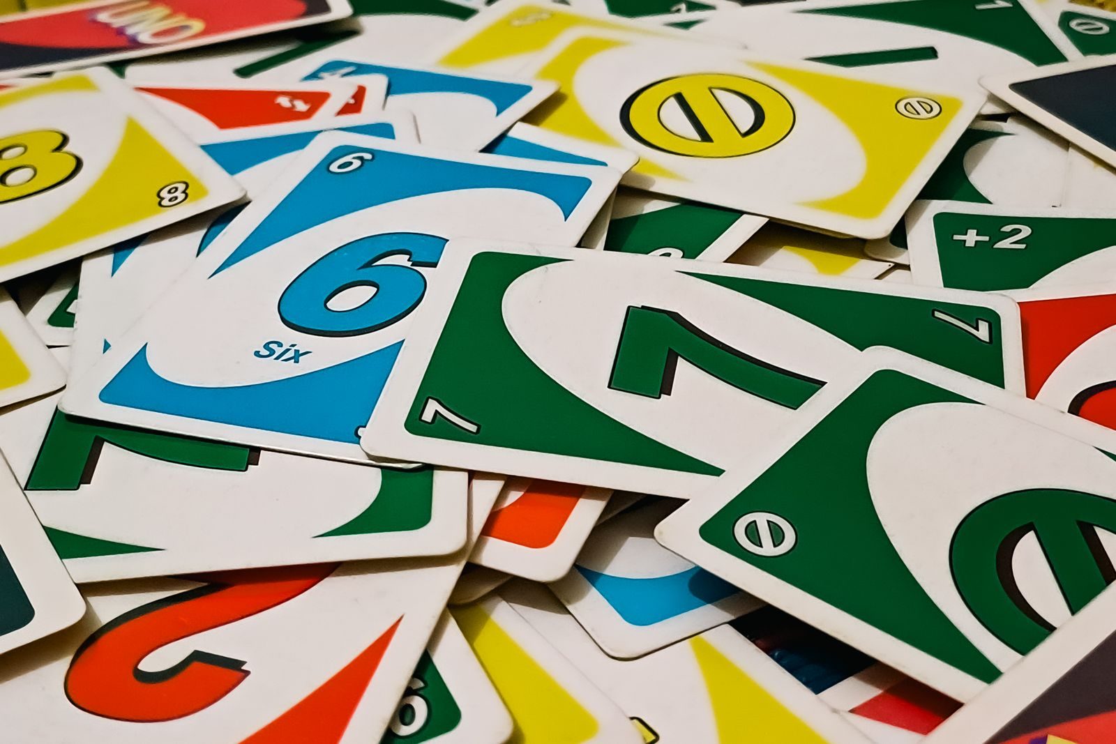Un tas de cartes du jeu Uno éparpillées, numéros et couleurs rouge, vert, bleu et jaune mêlés